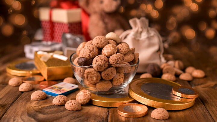Jar of kruidnoten surrounded by chocolate coins and gifts