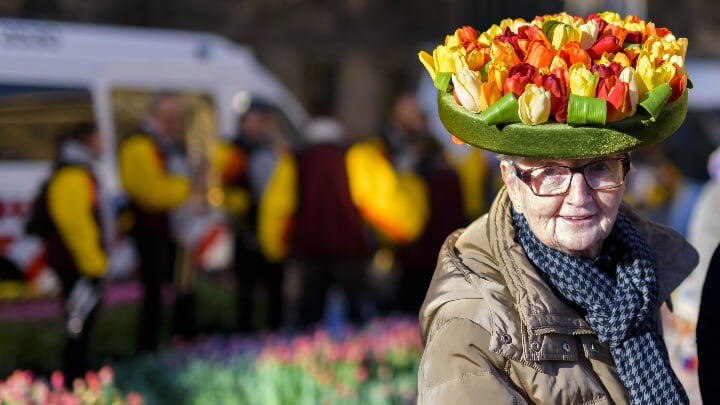 Old woman wearing a hat of tulips for National Tulip Day