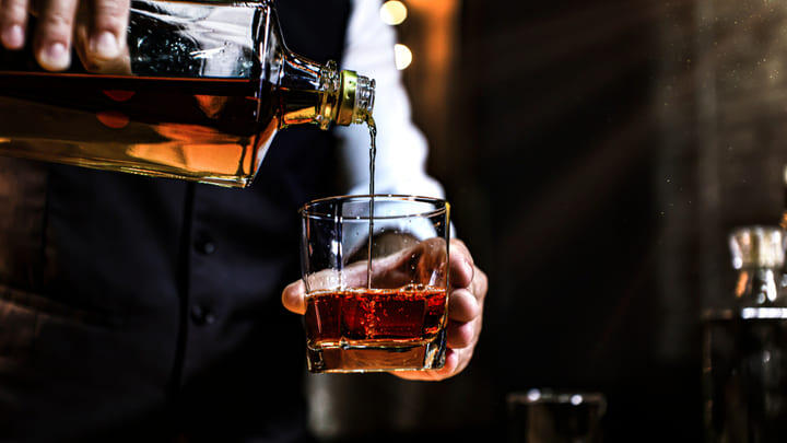 Whisky poured from a decanter into a glass.