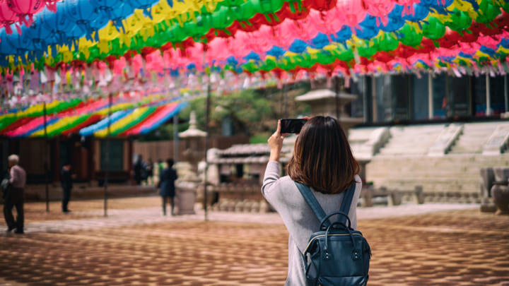 Tourist photographing colorful lanterns at the Bongeunsa Temple in Seoul.