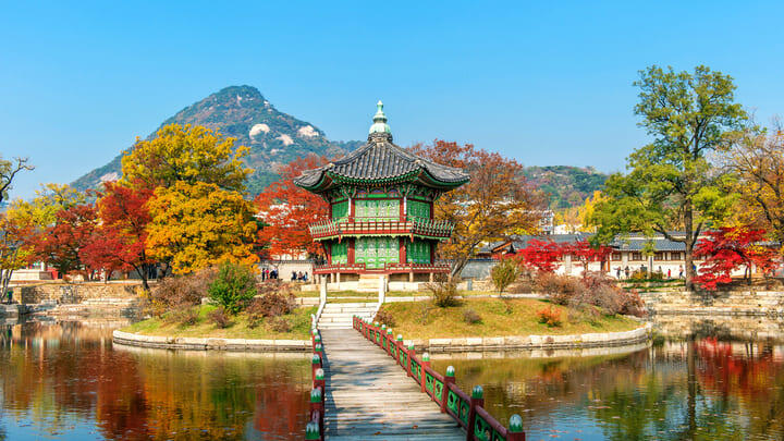 Gyeongbokgung Palace in autumn, against a mountain backdrop.