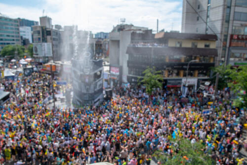 Crowd at a festival in Seoul, getting cooled down by a water cannon