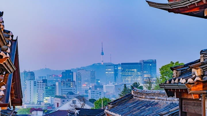Distant view of N Seoul Tower rising above the Seoul skyline at dusk.