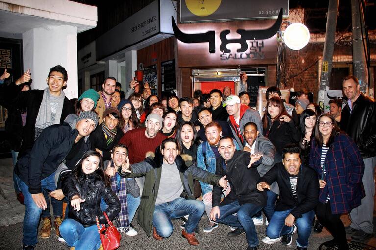 Group of people posing for a photo outside a nightclub in Seoul