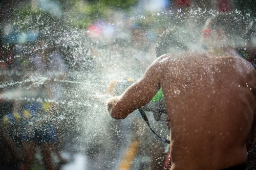 A young man is sprayed with water in the street
