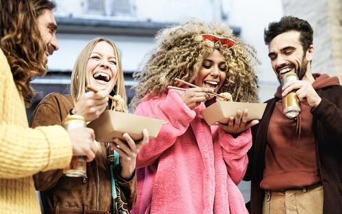 Four friends enjoying beer and street food