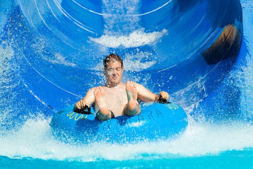 Man riding a blue water slide