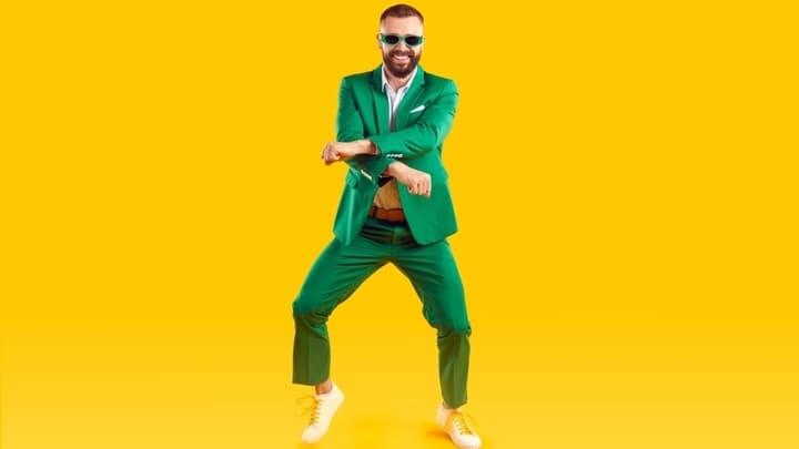 Man in a green suit performing the Gangnam Style dance.