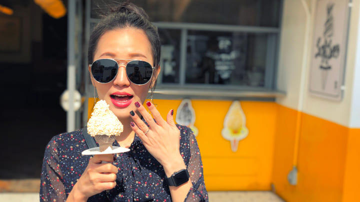 Woman in sunglasses eating an ice cream in Seoul.