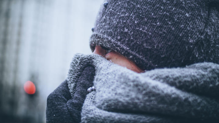 Tourist wrapped up against the cold in hat, scarf and gloves.