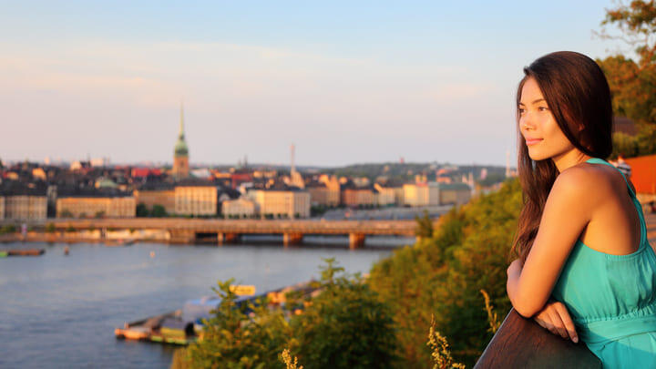 Woman watching the sun set over Stockholm and Lake Mälaren