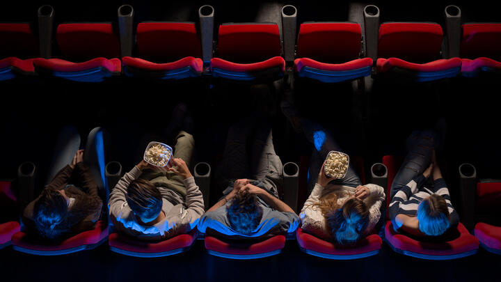 People eating popcorn in a darkened movie theater