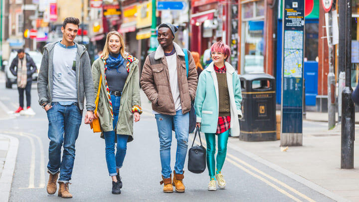 Group of friends walking along Brick Lane in East London.