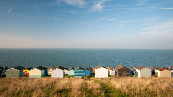 Colorful beach huts line the shore in Whitstable, Kent