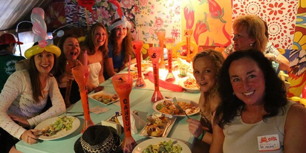 Adult women eating Mexican food with balloon hats on.