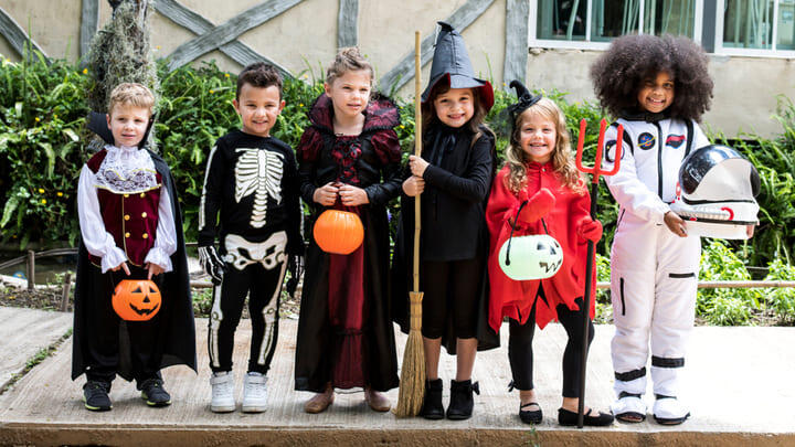 Cute kids in costume ready for trick or treating at Halloween