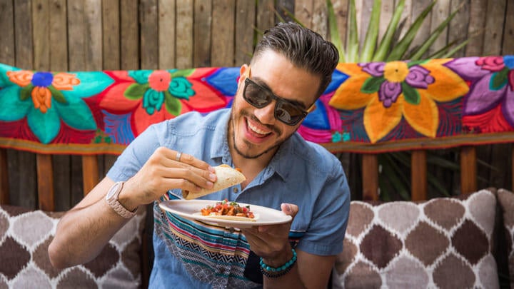 Man in sunglasses eating a taco