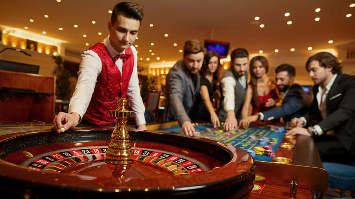 Casino croupier taking bets at the roulette wheel