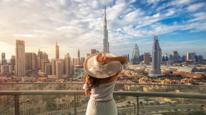 Woman holding her hat whilst looking at Dubai