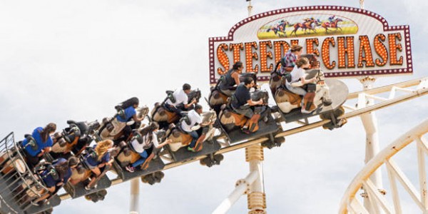 A roller coaster with people on it in motion.