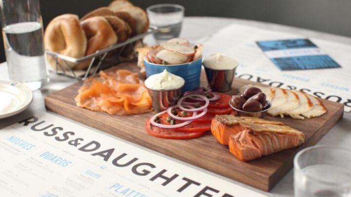 Platter of Lox - salmon served with cream cheese, sliced tomato, olives and a basket of bagels.