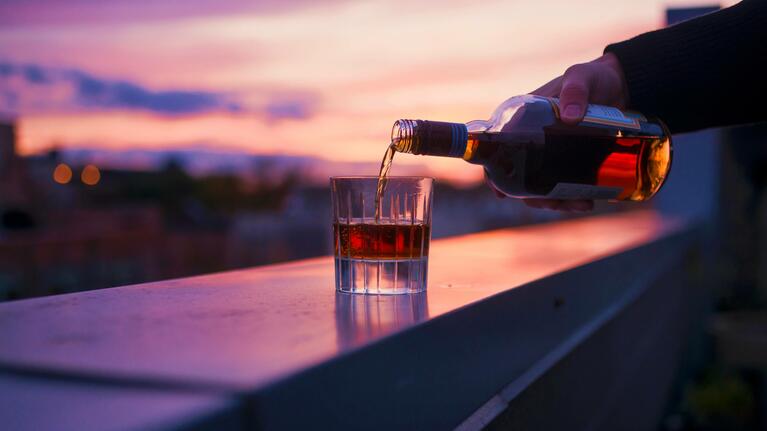 A bottle of whisky being poured from a rooftop