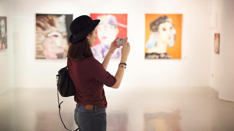 Woman with a smartphone in an art gallery