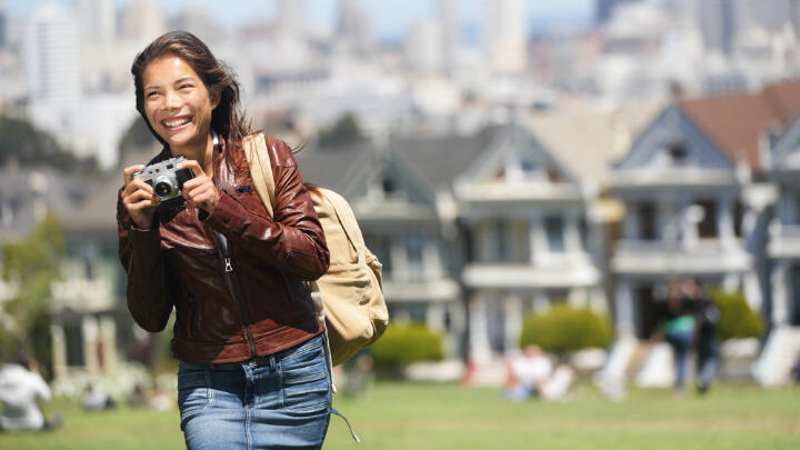 Smiling photographer passing through Alamo Square Park