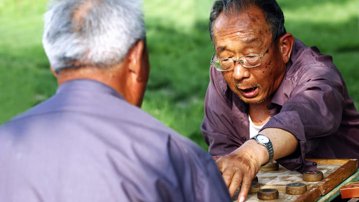 Men playing Chinese chess in the park