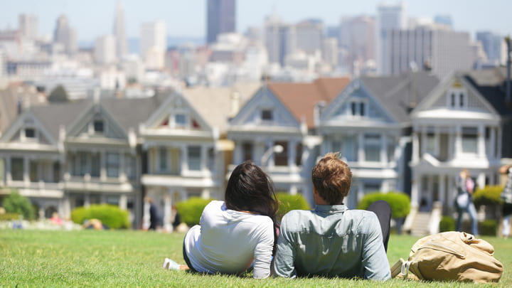 Couple admiring the Painted Ladies from the lawns of Alamo Park, San Francisco