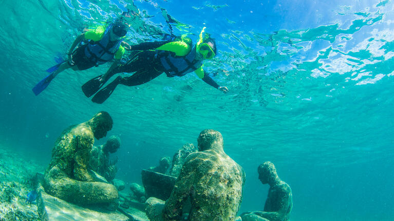 Snorkelers explore the sculptures of Cancun's underwater museum