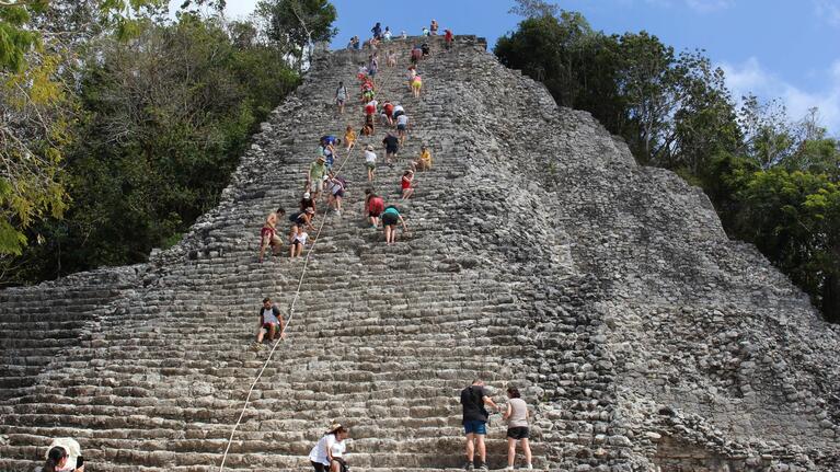 Visitors tackling Coba's Maya pyramid