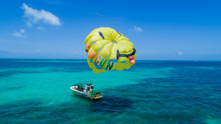 Speedboat with parasail inflated above it in Cancun