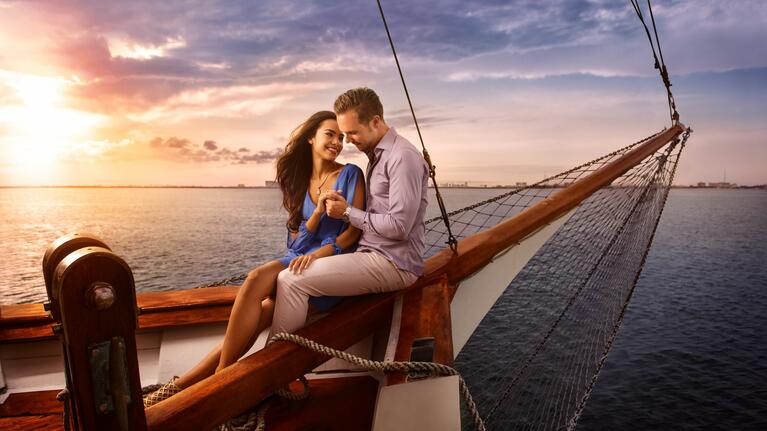 A couple take in the sunset during a romantic Cancun dinner cruise