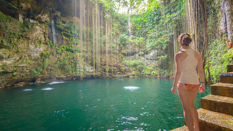 A visitor marvels at the cool waters of a cenote in Cancun in March