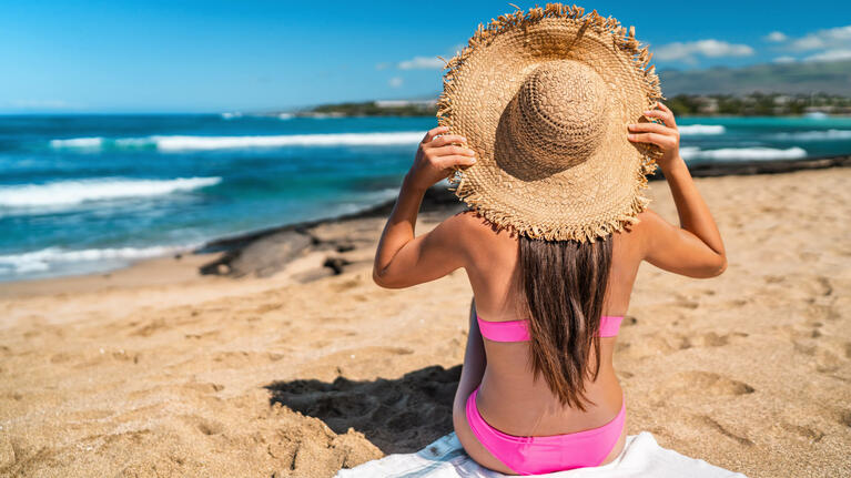 A woman shades herself from the sunny April skies in Cancun