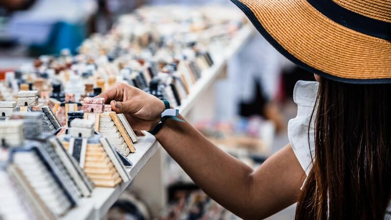 A woman decides between souvenirs at a Cancun stall