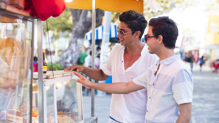 Men sample the local cuisine at a food stall in Cancun