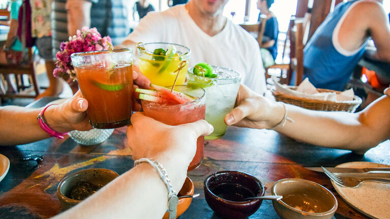 Friends share cocktails in a Cancun bar