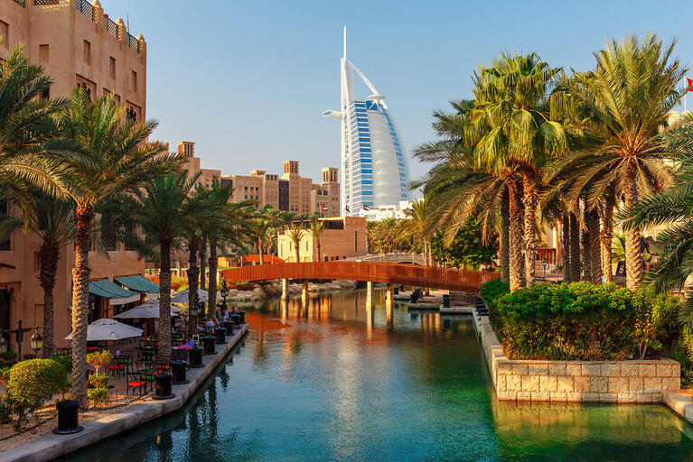 Gebäude und Palmen entlang eines Kanals in Dubai