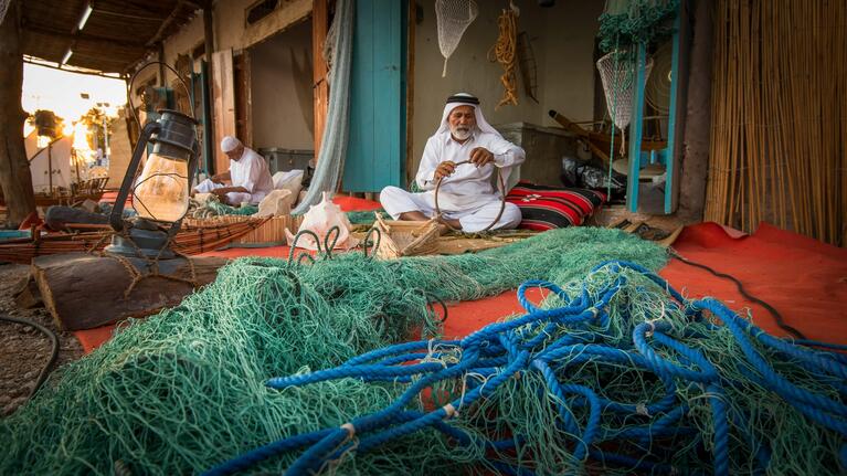 A fisherman mends his nets