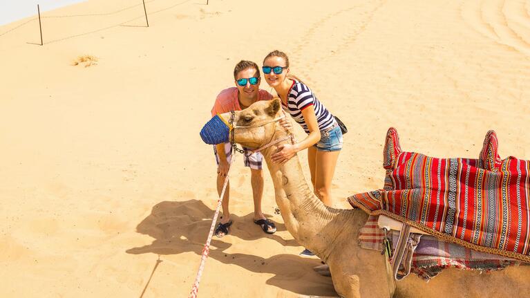 A couple share a photo with a camel