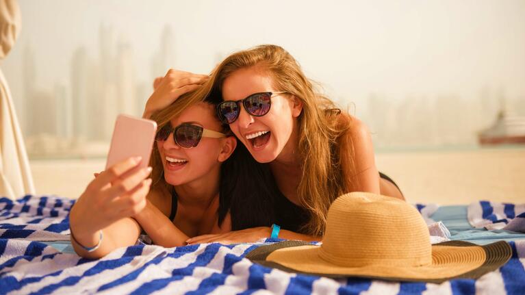 Two girls mess about on a Dubai beach