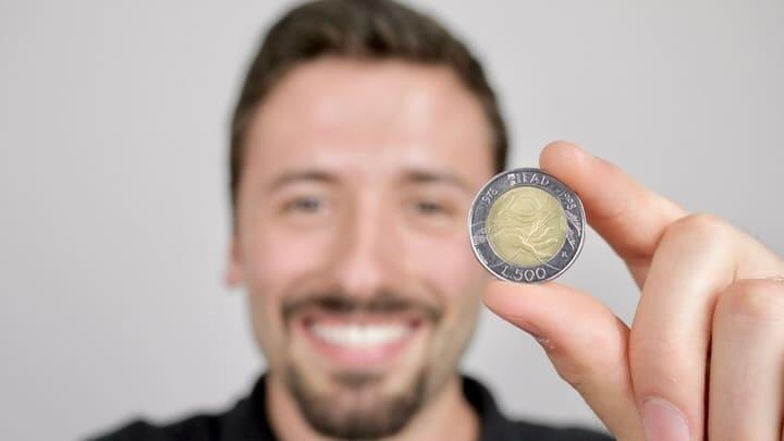 Man holding a 50 lira coin, which looks very similar to the 2 euro coin
