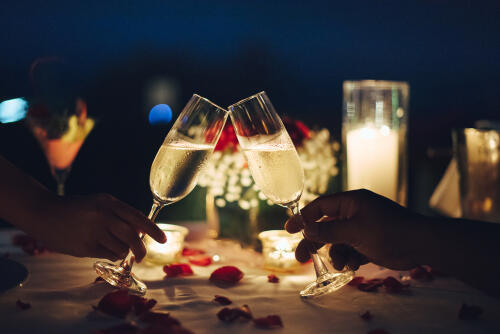 Clinking champagne glasses at night