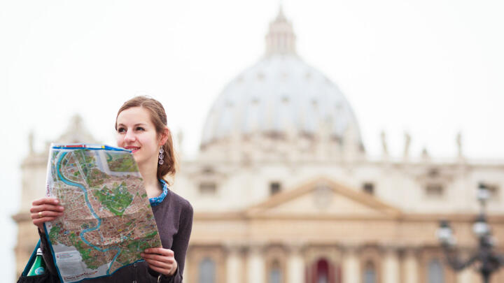 Female tourist consulting a map in front of St. Peter's Basilica