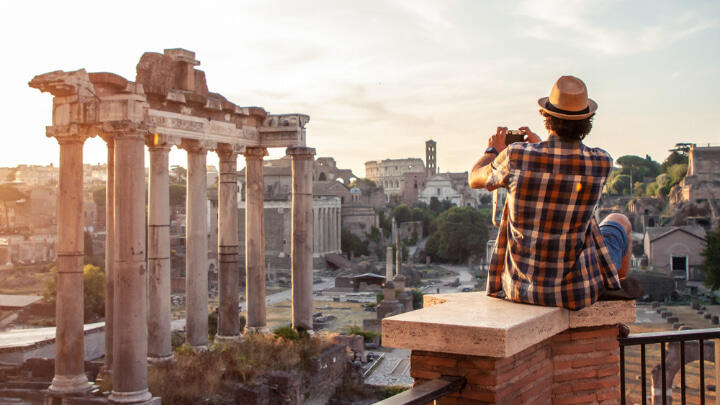 Tourist taking photos of the Roman Forum while perched on a balcony