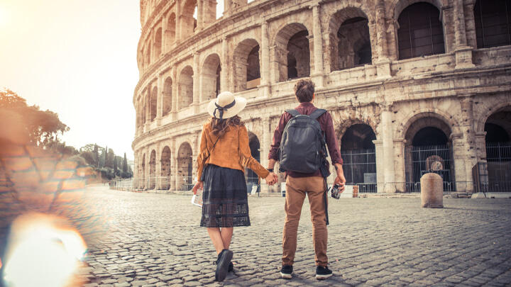 Couple holding hands while looking at the Colosseum
