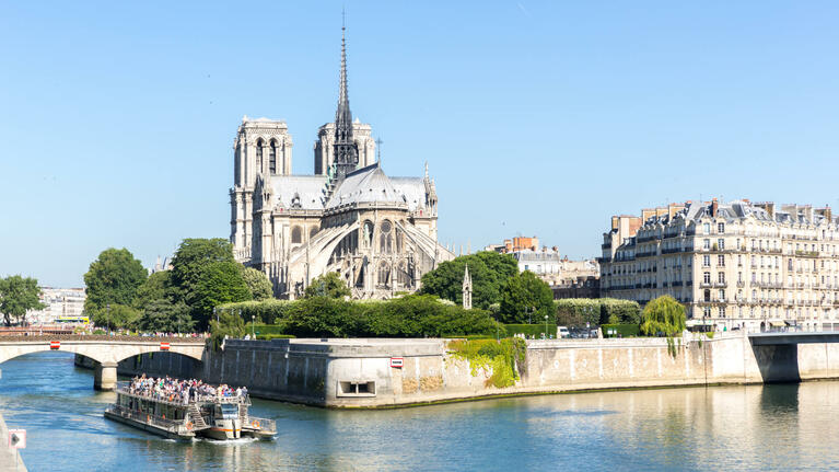A Seine cruise ship passes Notre Dame Cathedral