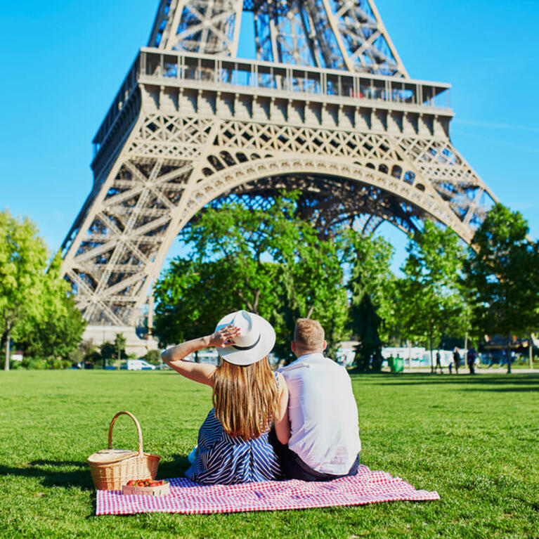 A couple picnicking by the Eiffel Tower